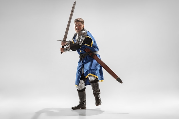 Храбрый бронированный рыцарь с профессиональным боевым оружием, изолированные на белом фоне студии.