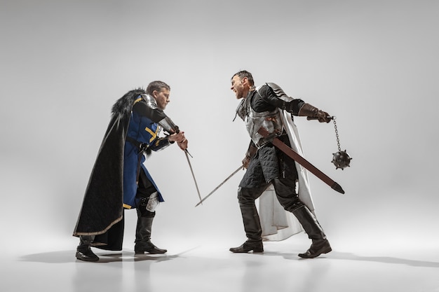 Храбрые бронированные рыцари с профессиональным боевым оружием, изолированные на белом фоне студии.