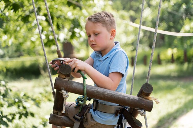Храбрый мальчик веселится в парке приключений