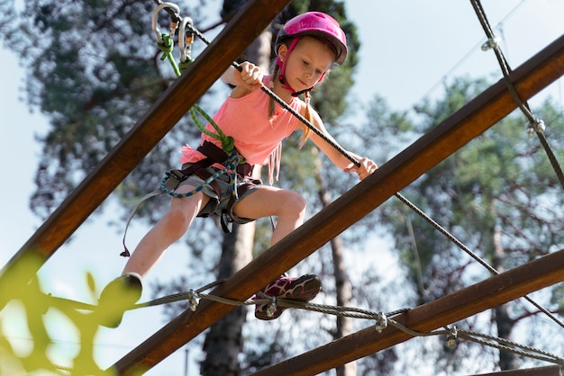 Foto gratuita ragazza coraggiosa che si diverte in un parco avventura