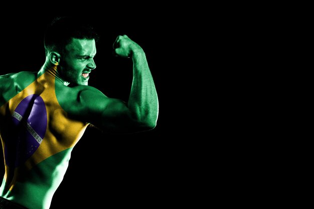 Brazil flag on handsome young muscular man black background