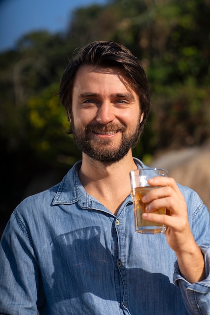 Foto gratuita uomo brasiliano che beve guaranà all'aperto