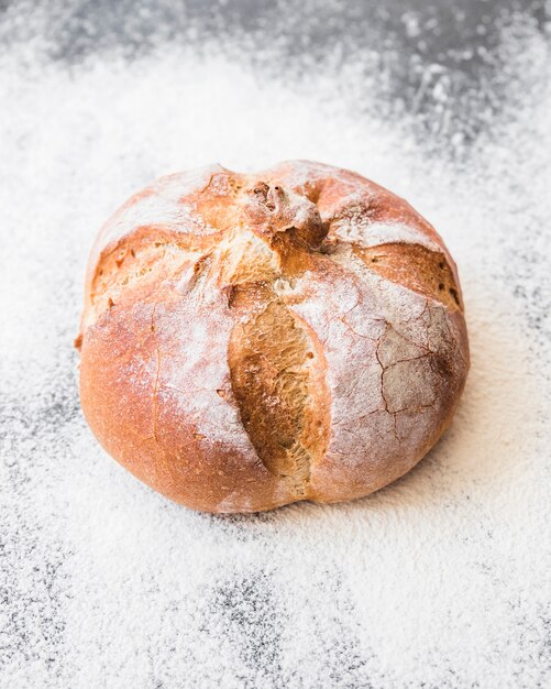 Bread bun on desktop with flour 