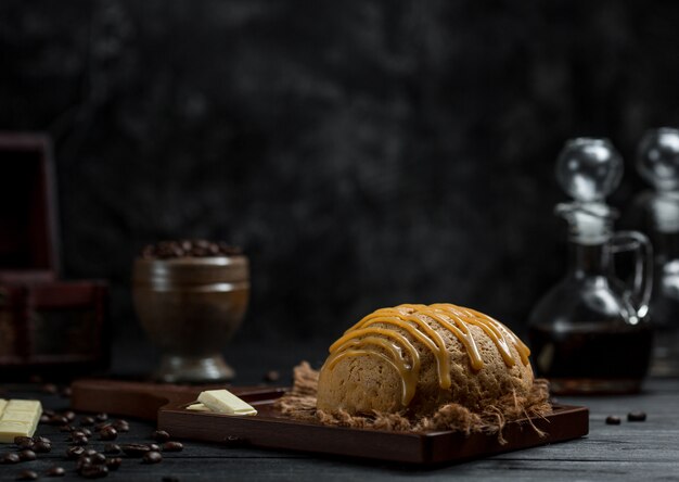 A bread bun served with caramel sauce on it in a cafe