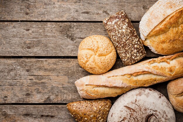 Bread and buns top view with wooden background