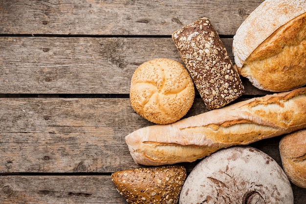Вид сверху хлеб и булочки с деревянными фоне