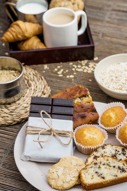 Bread, cookies, cupcake and dark chocolate on plate