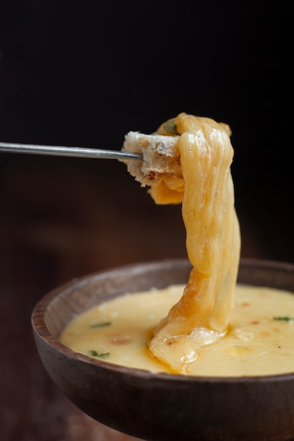 Bread dipped in melted cheese