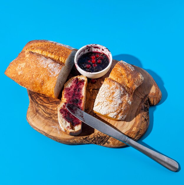 Bread and jam with leftover crumbs on wooden board