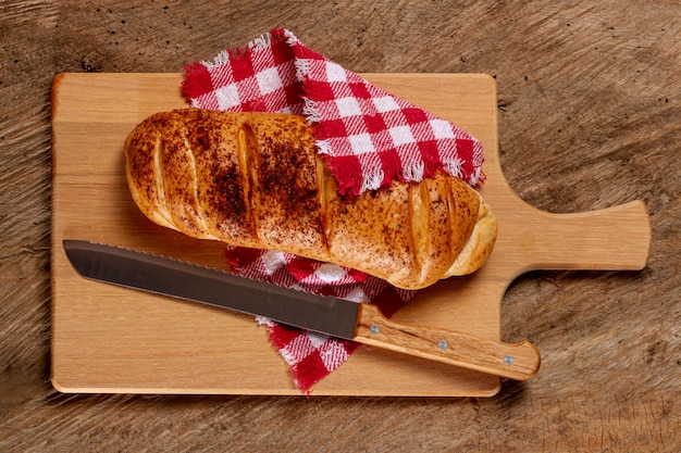 Bread and knife on wooden board