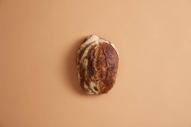 Bread loaf made of organic ingredients whole wheat, buckwheat, rye and without yeast. Multigrain bakery product on beige background. Healthy food and nutrition concept. Baking freshness every day