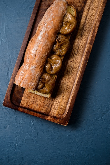 Bread long loaf and fig on wooden board