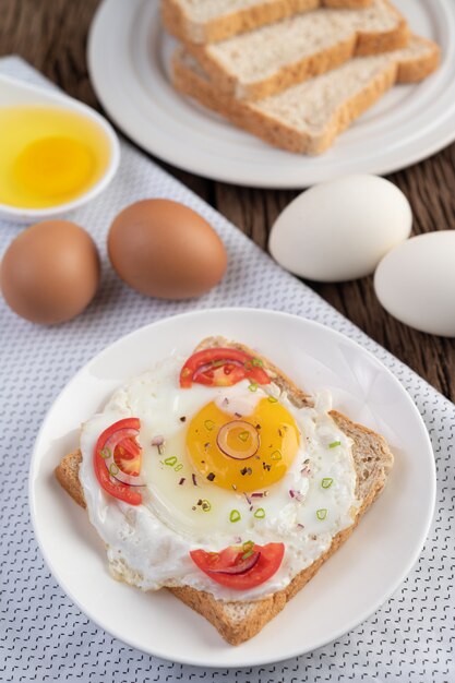 Bread placed with a fried egg with tomatoes, tapioca flour and sliced ​​spring onions.