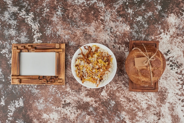 Fette di pane su marmo con contorno di riso.