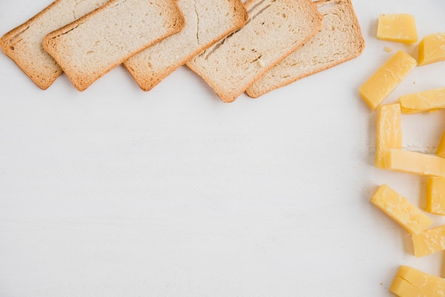 Bread slices with cheddar cheese slice on white background