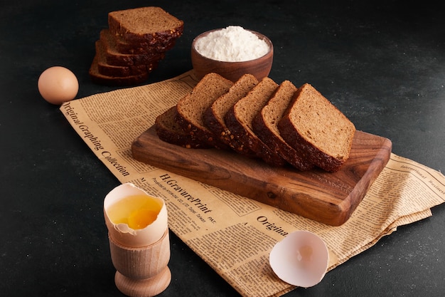 Bread slices with ingredients on the wooden board. 