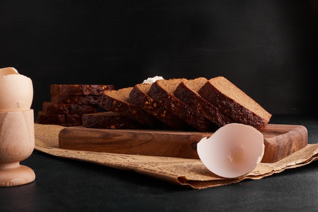 Bread slices with ingredients on the wooden board