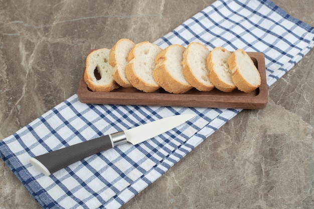 ナイフで木の板にスライスしたパン。高品質の写真