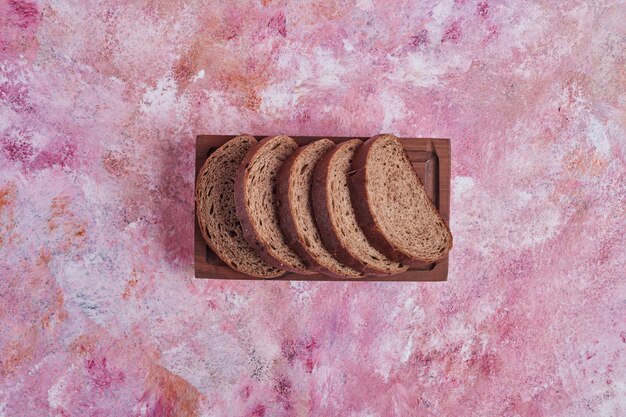 Foto gratuita fette di pane su un piatto di legno.