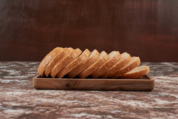 Bread slices on wooden platter.