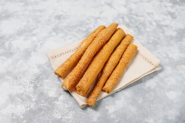 Bread sticks with sesame seeds on grey concrete ,top view