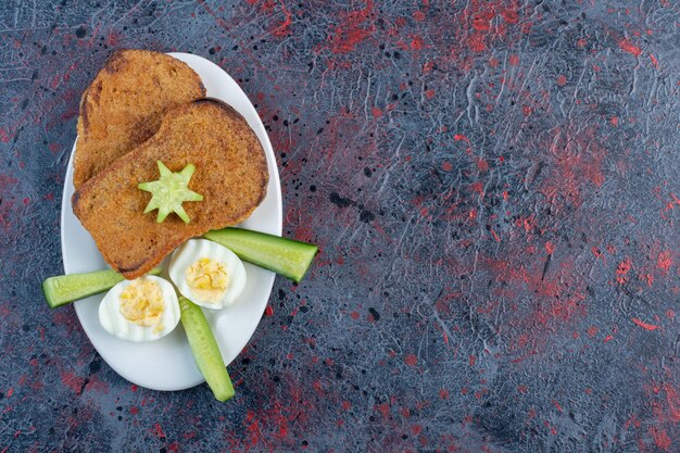 Bread toast with boiled egg and cucumbers. 