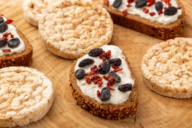 bread toasts with dried fruits and cream along with cookies on wood