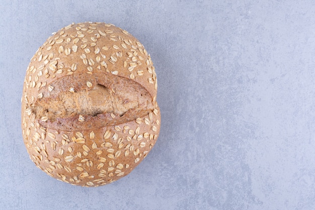 Bread with flake coated crust on marble surface