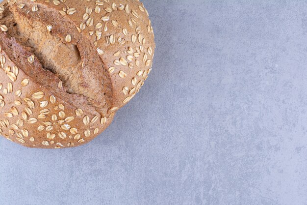 Bread with flake coated crust on marble surface