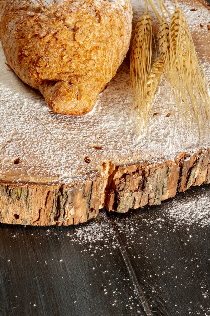 Bread with wheat on wooden board