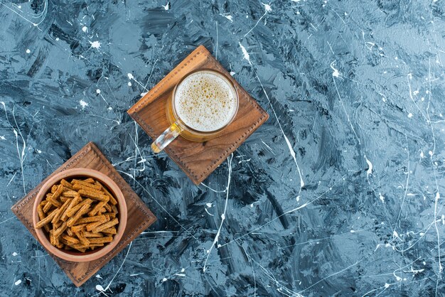 Breadcrumbs and beer on a board, on the marble table. 