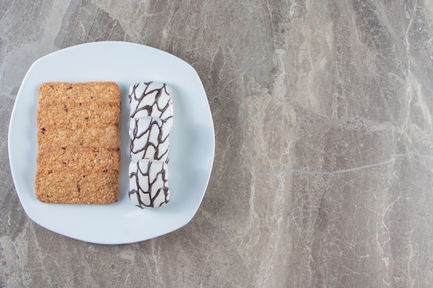 Free photo breadcrumbs and candies on a plate on marble.