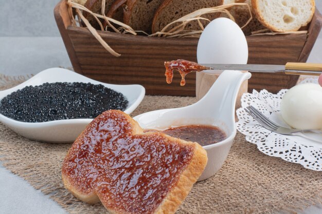 Breads and eggs with jam on sackcloth.