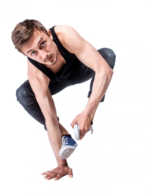 Break dancer doing one handed handstand against a white background