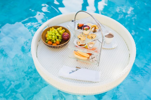 Breakfast and afternoon tea set floating around swimming pool