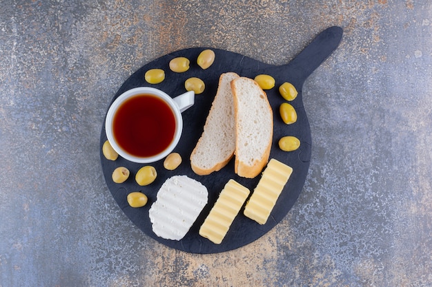 Free photo breakfast board with bread and a cup of tea