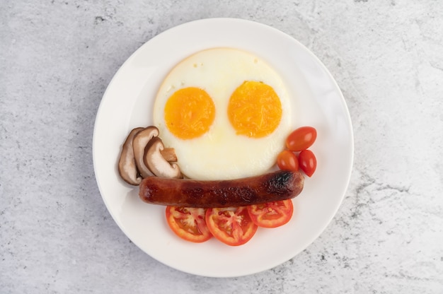 Breakfast consisting of bread, fried eggs, tomatoes, Chinese sausage and mushrooms.