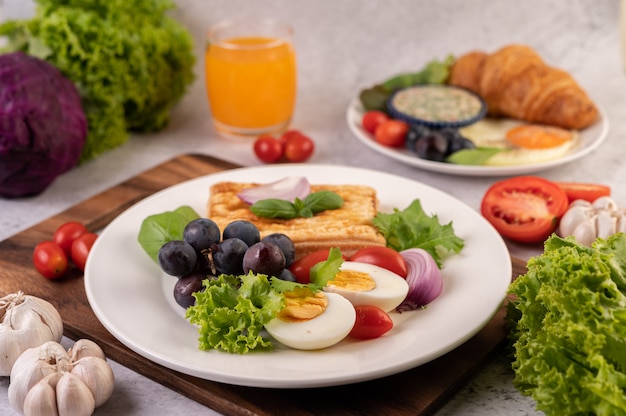 朝食は、パン、ゆで卵、黒ブドウのサラダドレッシング、トマト、スライスした「玉ねぎ」で構成されています。