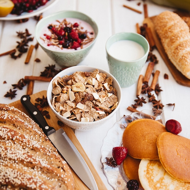 Foto gratuita decorazione per la colazione con ciotole di yogurt e cereali