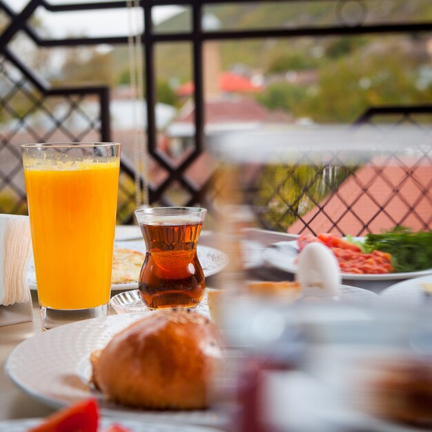 オレンジジュースとお茶の側面図と屋外での朝食