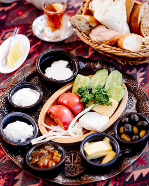 Breakfast platter with mxed foods , bread and a glass of tea.