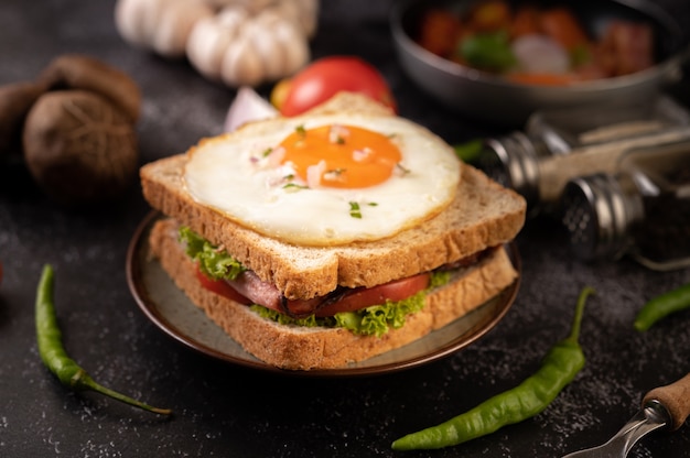 빵, 계란 후라이, 햄, 양상추로 만든 아침 샌드위치.
