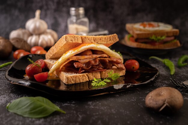 Breakfast sandwich made with bread, fried egg, ham, and lettuce.