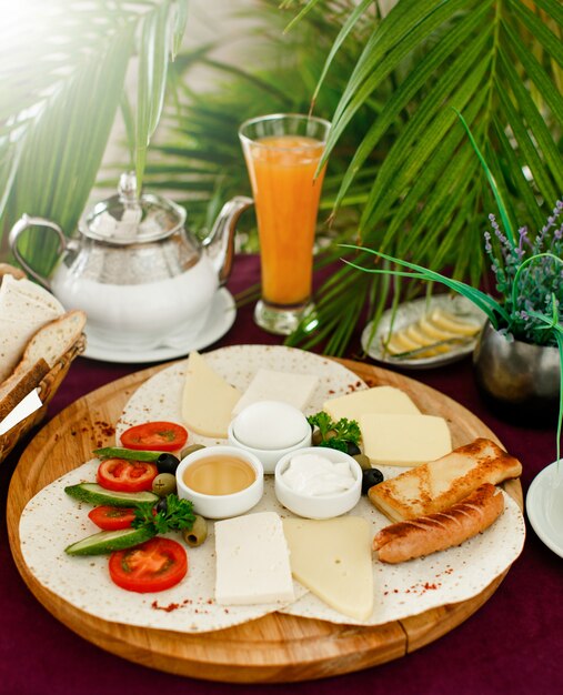 Breakfast setup with breakfast platter, orange juice and teapot