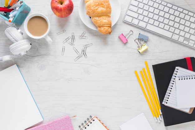 Breakfast; stationeries and keyboard on wooden desk