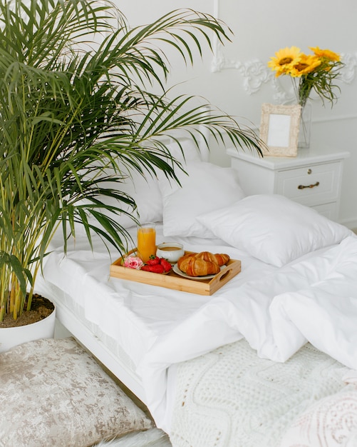 Breakfast tray put on the single bed with white bedding