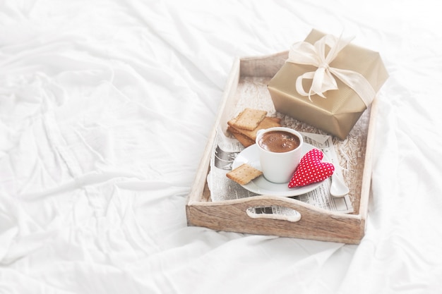 Breakfast tray with coffee, a gift and a heart