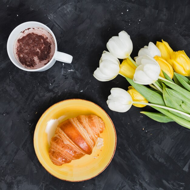 Breakfast with croissant and flowers