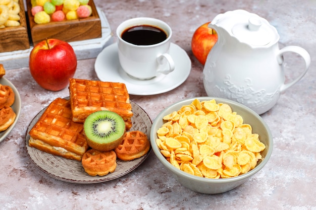 さまざまなお菓子、ウエハース、コーンフレーク、一杯のコーヒー、トップビューで朝食します。