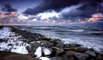 Free photo breakwater with snow at sunset